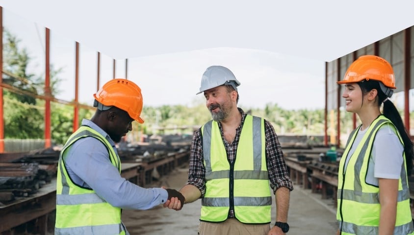 WorkWell Surrey stock image showing three people in high vis jackets on a construction site