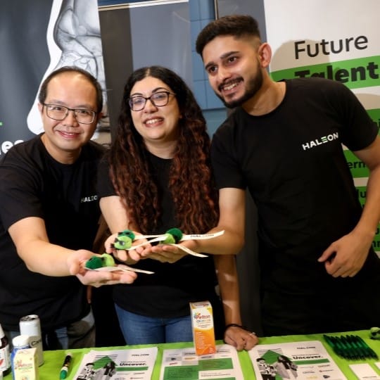 Three people in Haleon t-shirts pose for a picture while at a careers exhibition