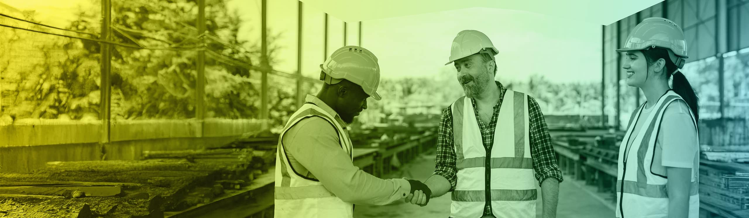 Three people wearing hard hats and high vis jackets on a building site